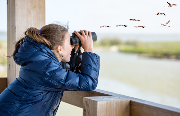 girl watching through binoculars