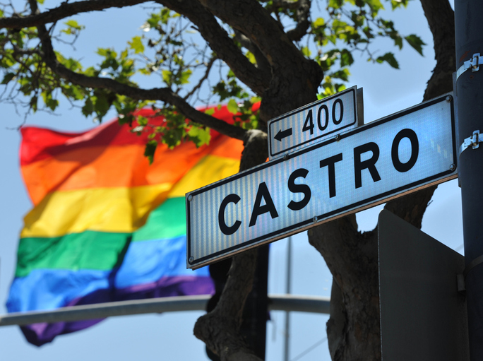"a street sign in San Francisco for the 'Castro' area which is a famous Gay and lesbian district. The rainbow flag in the background is also used a symbol by the Gay communityCalifornia, USA"